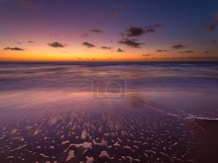 Photo for A seascape during sunset. Sand on the seashore. Bright sky during sunset. A sandy beach at low tide. Long exposure. Photo for wallpaper. - Royalty Free Image
