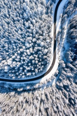 Téléchargez les photos : Vue aérienne sur la route et la forêt en hiver. Paysage hivernal naturel de l'air. Du froid hivernal. Forêt et neige. Paysage d'un drone. - en image libre de droit