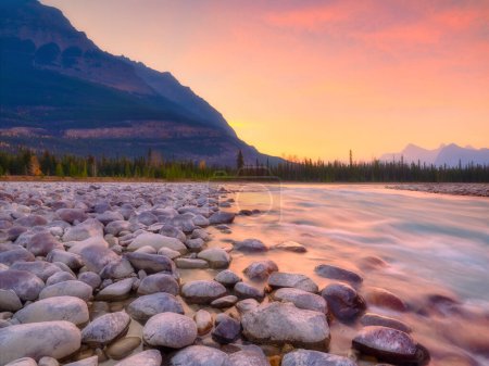 Téléchargez les photos : Parc national Banff, Alberta, Canada. Paysage au lever du soleil. Rochers ronds sur la rive. Montagnes et forêt. Couleurs vives à l'aube. Paysage naturel. - en image libre de droit