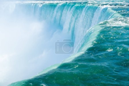 Téléchargez les photos : Niagara Falls. View from the Canadian side. Rapid flow of water. A water cloud near a waterfall. Nature scenery. Photo for advertising. - en image libre de droit