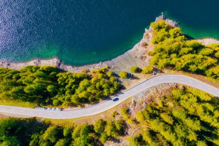 Photo for The road near turquoise lake. Aerial landscape. The road by the lake in Switzerland. Summer landscape from the air. Forest and road with curves. - Royalty Free Image