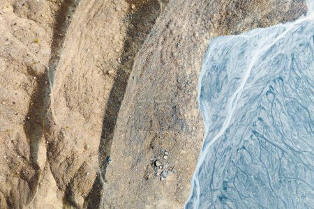 Téléchargez les photos : Drone view of the river in the glacier valley. View of the moraines. Landscape from the air.  River on a moraine. Landscape with soft light before sunset. Abstract view for wallpaper. - en image libre de droit