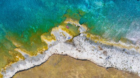 Téléchargez les photos : Vue aérienne sur bateau sur la mer Méditerranée bleue par temps ensoleillé. Vue de l'air sur les vagues et les rochers. Détente en mer et voyage. Une journée ensoleillée pendant les vacances d'été. Vue du dessus du drone. - en image libre de droit