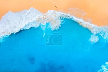 Photo for An aerial view of the people on the beach. Coast as a background from top view.  Waves and beach. Seascape. Azure water background from drone. Vacation time. - Royalty Free Image