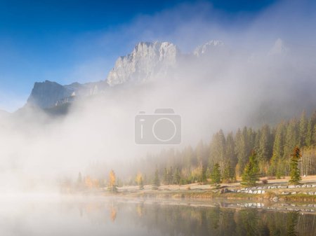 Téléchargez les photos : Tomber. Un matin brumeux à l'aube. Arbres d'automne sur la rive de la rivière. Montagnes et forêt. Réflexions à la surface du lac. Parc national Banff, Alberta, Canada. - en image libre de droit