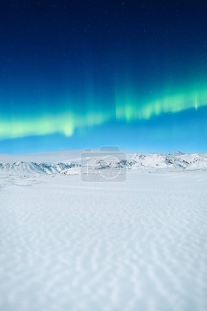Photo for Aurora Borealis. Northern lights and clear skies. Nature. Scandinavian countries. Snow and ice on the mountains. Landscape in winter time. Photo for background and wallpaper. - Royalty Free Image