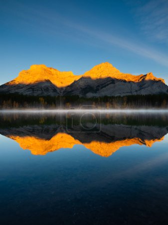 Foto de Mountain landscape at dawn. Foggy morning. Lake and forest in a mountain valley at dawn.Reflections on the surface of the lake. Wedge Pond, Banff National Park, Alberta, Canada. - Imagen libre de derechos