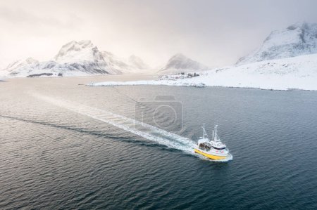 Téléchargez les photos : Bateau de pêche dans le fjord. Vue aérienne des îles Lofoten, Norvège. Pêche industrielle. Vue depuis un drone. Paysage aérien. Montagnes et eau. Image de la Norvège - en image libre de droit