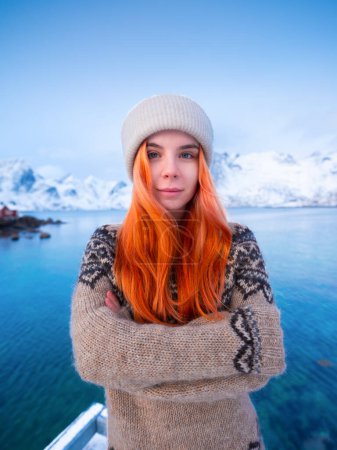 Téléchargez les photos : Fille islandaise autochtone aux cheveux roux. Vêtements traditionnels nationaux. Pull à motifs. Portrait d'une jeune fille. Voyage et aventure. - en image libre de droit