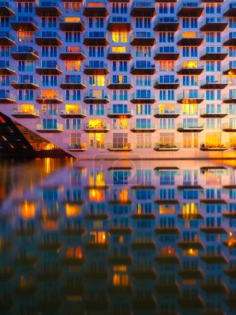 Téléchargez les photos : Amsterdam, Pays-Bas. Un paysage urbain au coucher du soleil. Un immeuble près de l'eau dans la baie. Architecture des Pays-Bas. Photographie de voyage. - en image libre de droit