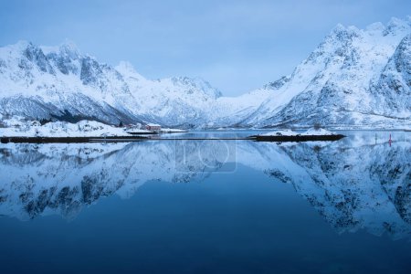 Foto de Islas Lofoten, Noruega. Montañas y reflexión sobre la superficie del agua. Hora de la tarde. Paisaje invernal cerca del océano. Noruega viajes - Imagen libre de derechos