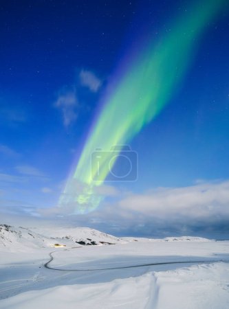 Photo for Aurora Borealis in Iceland. Northern Lights over the road. A winter night landscape with bright lights in the sky. Landscape in the north in winter time. A popular place to travel. - Royalty Free Image