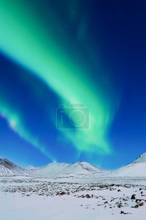 Téléchargez les photos : Aurora Borealis. Aurores boréales sur les montagnes. Un paysage nocturne hivernal avec des lumières vives dans le ciel. Paysage dans le nord en hiver. Un endroit populaire pour voyager. - en image libre de droit