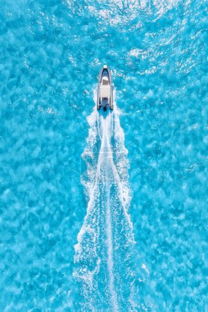 Téléchargez les photos : Vue aérienne sur bateau rapide sur mer bleue par temps ensoleillé. Vacances et loisirs. Navire rapide à la surface de la mer. Paysage marin depuis le drone. Paysage marin avec bateau à moteur. - en image libre de droit