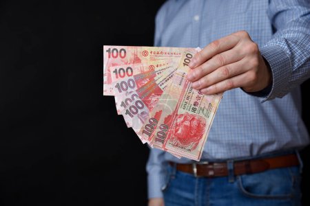 Photo for Businessman holding banknotes in his hand. Hong Kong dollars cash. - Royalty Free Image