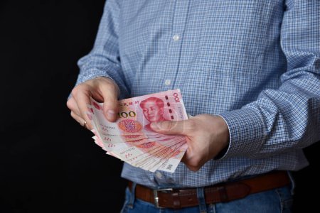 Geschäftsmann mit Geldscheinen in der Hand. Chinesischer RMB Bargeld.