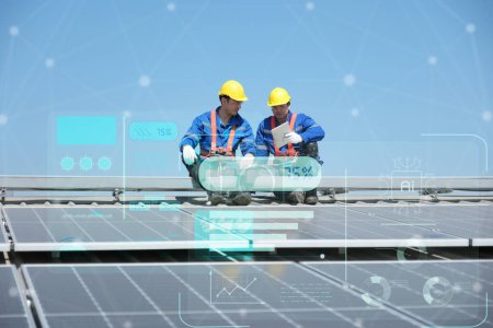 Ingenieure oder Arbeiter installieren und inspizieren Solarzellen auf dem Dach der Fabrik.