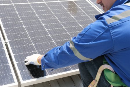Téléchargez les photos : Ingénieurs ou travailleurs installent et inspectent la cellule solaire sur le toit de l'usine. - en image libre de droit
