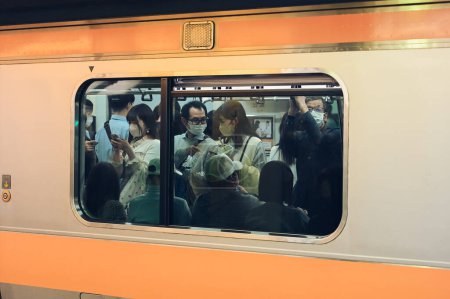 Foto de Tokio Japón 15 de mayo de 2023: Un vistazo a la cultura de los desplazamientos de Tokio: Conversaciones silenciosas en medio de la hora punta del metro - Imagen libre de derechos