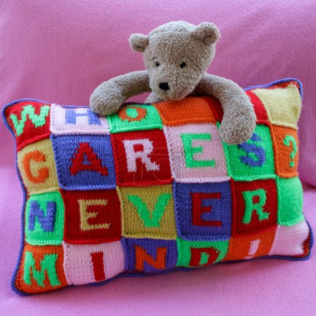 Téléchargez les photos : Oreiller tricoté à la main multicolore avec des phrases imprudentes et un ours en peluche - en image libre de droit