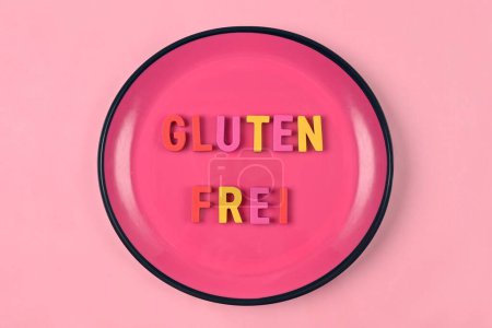 Photo for Pink plate with lettering " Glutenfrei " meaning Gluten free. Nutritional concept. - Royalty Free Image