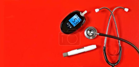 Foto de Medición de la diabetes junto al estetoscopio sobre fondo rojo. Imagen panorámica con espacio de copia. - Imagen libre de derechos