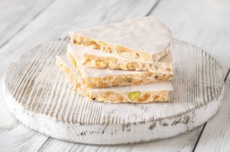 Photo for Wedges of turron nougat confection on wooden board - Royalty Free Image