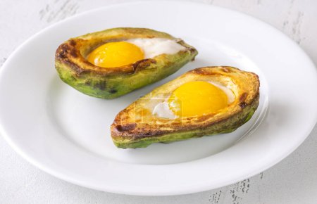 Photo for Breakfast dish of baked eggs in halved avocado - Royalty Free Image