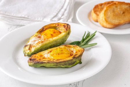 Photo for Breakfast dish of baked eggs in halved avocado - Royalty Free Image
