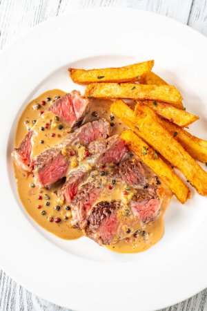 Photo for Steak au poivre - french steak with peppercorn sauce with french fries - Royalty Free Image