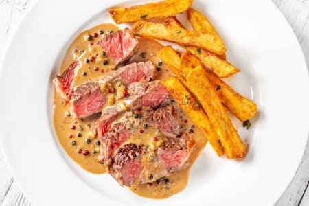 Photo for Steak au poivre - french steak with peppercorn sauce with french fries - Royalty Free Image