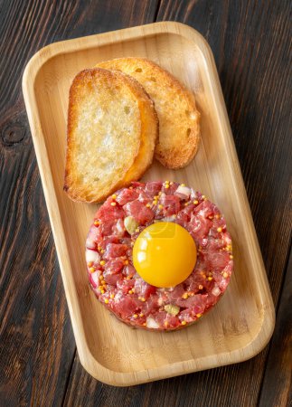 Photo for Portion of Beef steak tartare topped with a raw egg yolk - Royalty Free Image