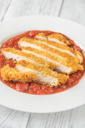 Chicken Milanese cutlet garnished with tomato sauce