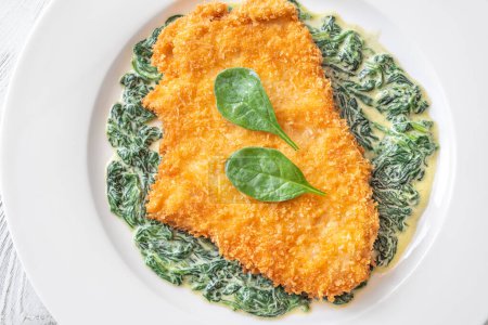Chicken Milanese cutlet garnished with creamed spinach