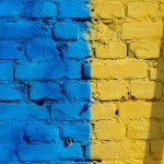 brick wall with yellow painted blue paint