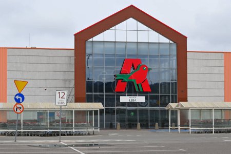 Téléchargez les photos : Rumia, Pologne - 16 avril 2023 : Logo d'Auchan sur la façade du magasin. Auchan est une chaîne d'hypermarchés française - en image libre de droit