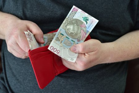 Hände halten Portemonnaie mit polnischem Geld. Konzept der finanziellen Absicherung im Alter im Ruhestand