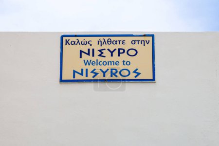 Board welcoming tourists to the island of Nisyros in the port of Mandraki. Greece. The inscription in English: Welcome to Nisyros