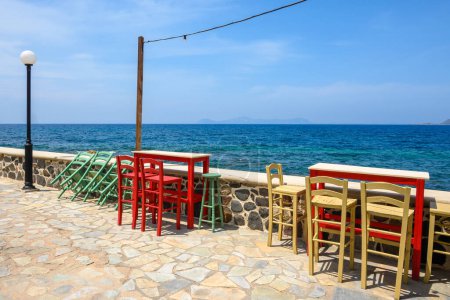 Tables and chairs in typical Greek seaside restaurant on Nisyros island. Greece