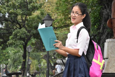 Téléchargez les photos : Lecture Jeune fille de l'école adolescent portant un sac à dos avec des ordinateurs portables - en image libre de droit