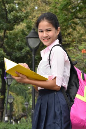 Téléchargez les photos : Asian Female Student Reading Wearing Backpack With Textbooks - en image libre de droit