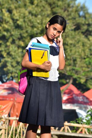 Foto de Estudiante toma de decisiones usando uniforme escolar con libros escolares - Imagen libre de derechos