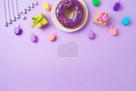 Photo for Jewish holiday Hanukkah concept with donuts, menorah, spinning tops and gift box on purple background. Top view, flat lay - Royalty Free Image