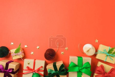 Téléchargez les photos : Coffrets cadeaux de Noël avec rubans colorés sur fond rouge. Emballage de vacances et concept d'emballage. En haut. Pose plate - en image libre de droit