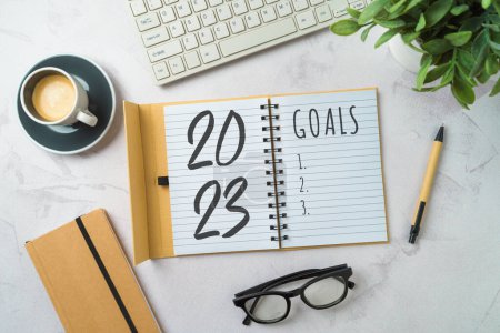 Photo for New Year 2023 goals and resolution business concept with notebook, coffee cup, computer keyboard and plant on modern background. Top view, flat lay - Royalty Free Image