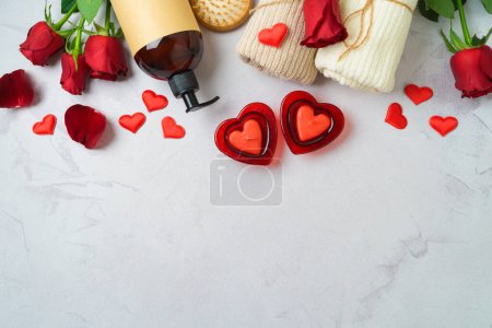 Foto de Spa treatment for Valentine's day background with  towels, rose flowers and candles. Top view, flat lay - Imagen libre de derechos