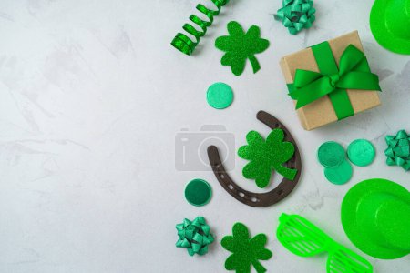 Foto de St Patrick's day holiday concept with lucky charms, shamrock and gift box on bright background. Top view, flat lay - Imagen libre de derechos