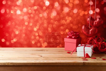 Photo for Valentines day background with empty wooden table, gift box and heart shapes. Holiday mock up for design and product display - Royalty Free Image