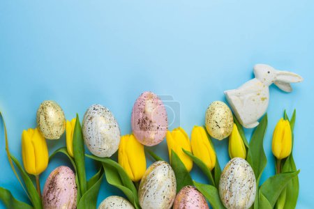Téléchargez les photos : Easter holiday border frame background with easter golden eggs and yellow  tulip flowers. Top view, flat lay - en image libre de droit