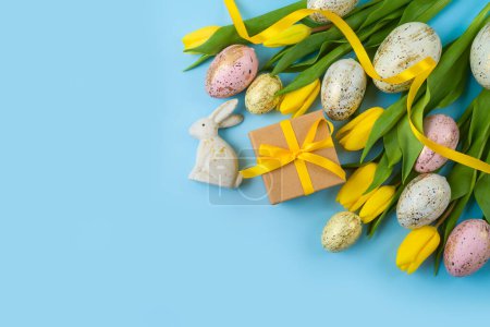 Foto de Fondo de vacaciones de Pascua con huevos de Pascua, caja de regalo y flores de tulipán amarillo. Vista superior, plano - Imagen libre de derechos